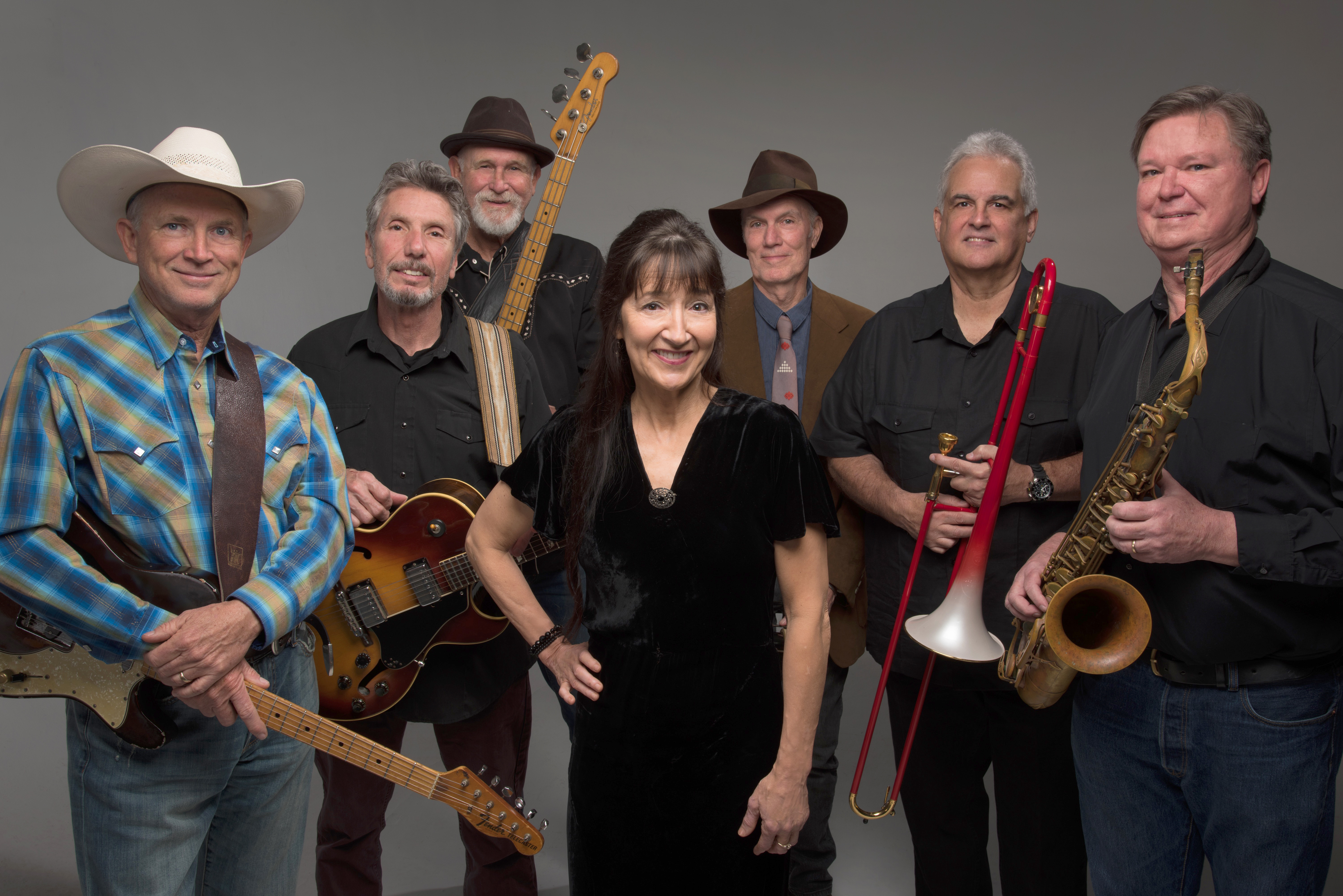 Band members posing with instruments, smiling together.