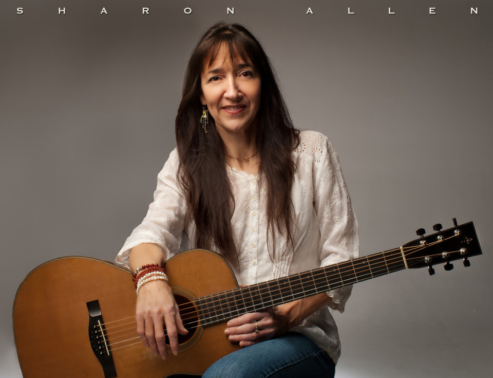 Woman with guitar, wearing white blouse.